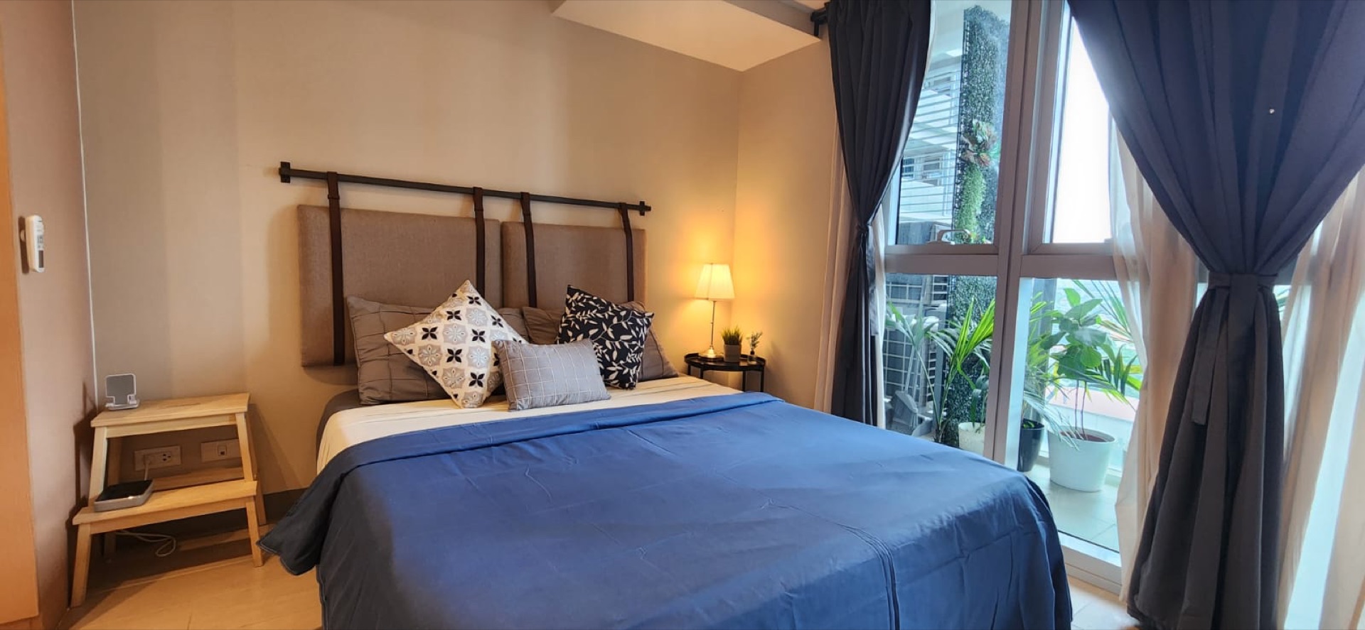 Uptown Parksuites Tower 2 Unit 7U — furnished bedroom with floor-to-ceiling windows and BGC skyline view
